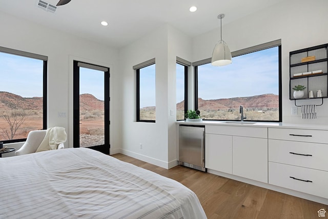 bedroom featuring a mountain view, sink, refrigerator, and light hardwood / wood-style floors