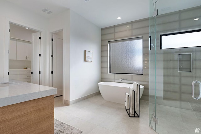 bathroom with tile patterned floors, vanity, and separate shower and tub
