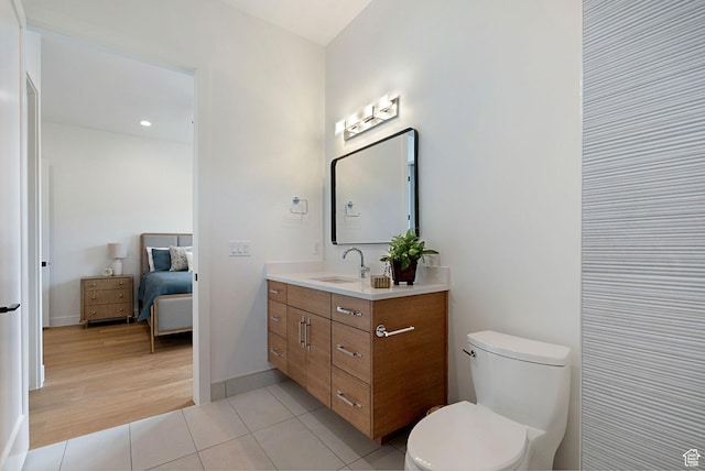bathroom featuring tile patterned flooring, vanity, and toilet