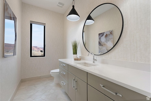 bathroom with tile patterned flooring, vanity, and toilet