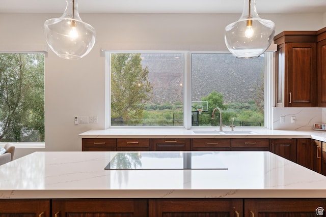 2712 S Rio Vista Dr, St George, UT 84790 - kitchen featuring tasteful backsplash, light stone counters, hanging light fixtures, and sink