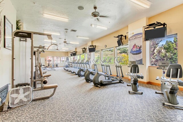 exercise room featuring ceiling fan and a textured ceiling