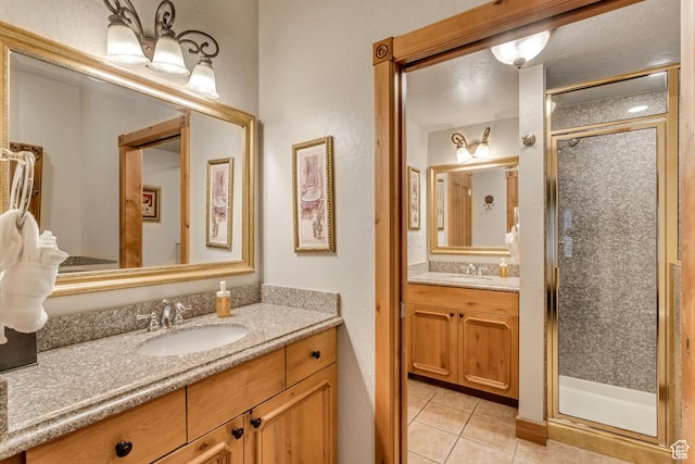 bathroom featuring tile patterned flooring, vanity, and a shower with shower door