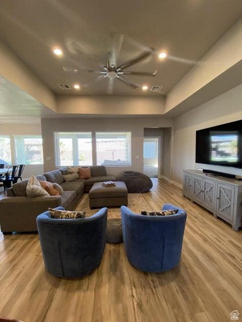 living room featuring light hardwood / wood-style floors and ceiling fan