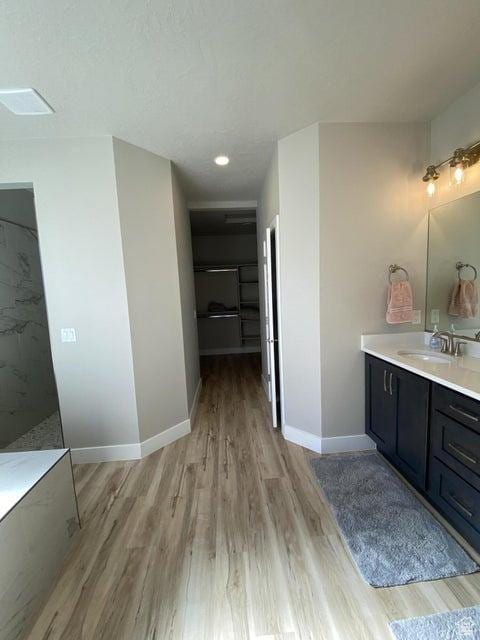 bathroom featuring vanity, wood-type flooring, and walk in shower