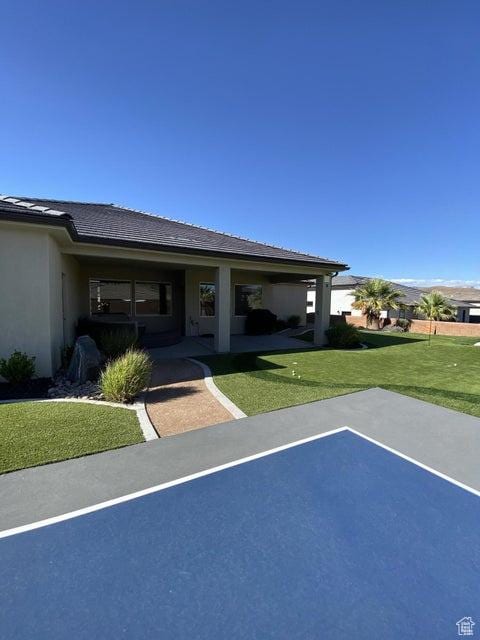exterior space featuring basketball court and a yard