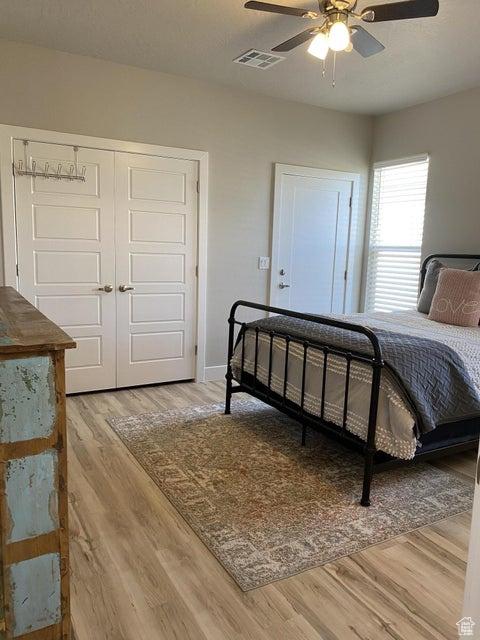 bedroom featuring ceiling fan, a closet, and hardwood / wood-style flooring