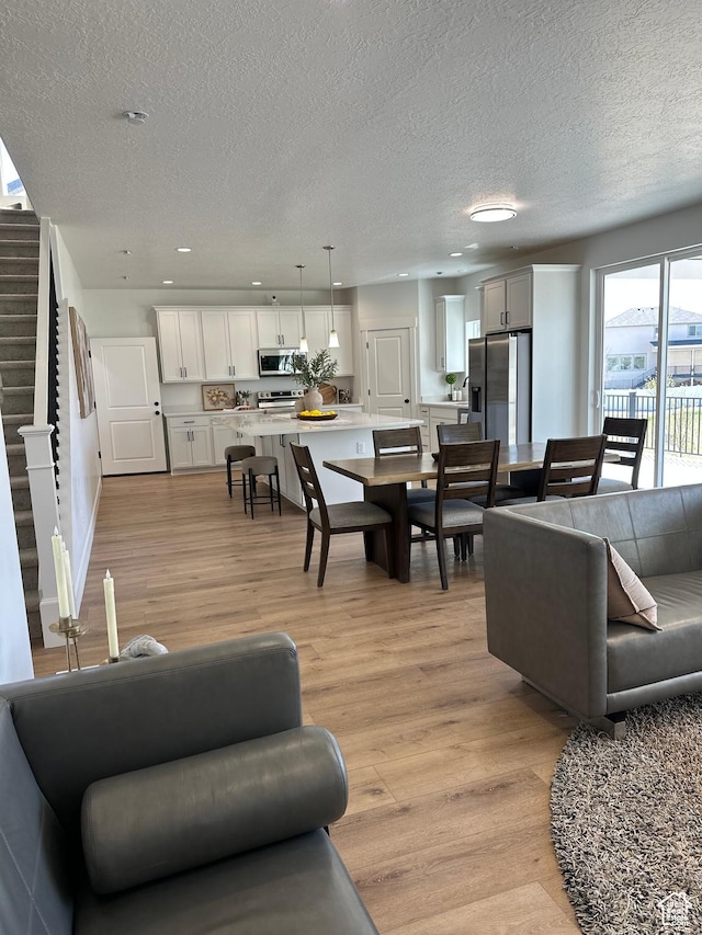 7949 N Bristlecone Rd Unit 206, Eagle Mountain, UT 84005 - living area featuring light wood finished floors, a textured ceiling, recessed lighting, and stairway