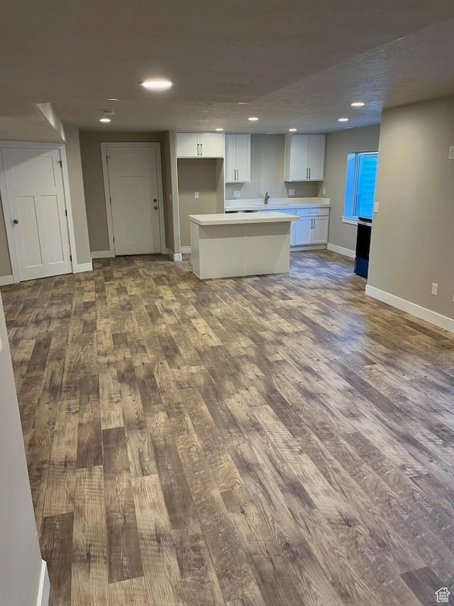 kitchen featuring white cabinets, a center island, sink, and hardwood / wood-style floors