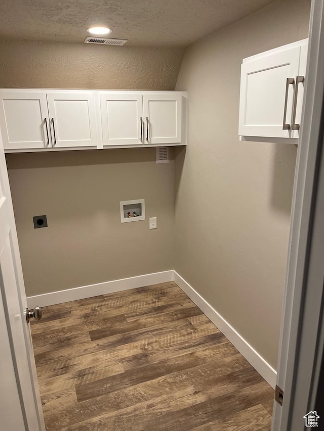 clothes washing area featuring electric dryer hookup, hookup for a washing machine, cabinets, and dark hardwood / wood-style floors