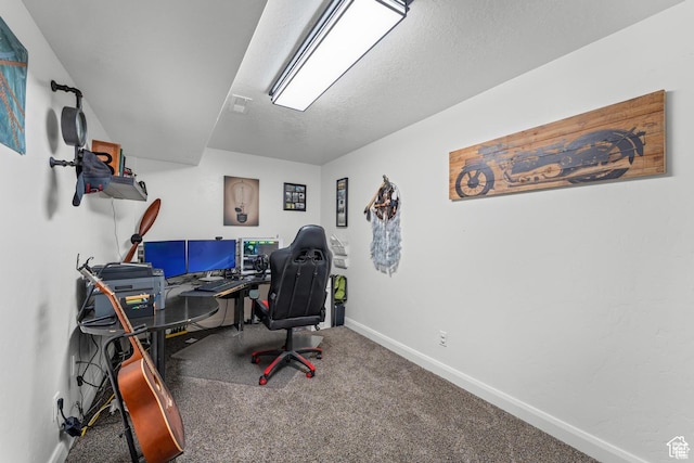 carpeted home office featuring a textured ceiling