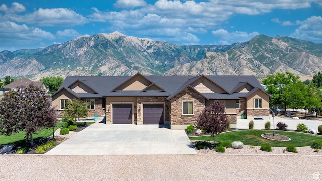 view of front of house featuring a mountain view, a garage, and a front lawn