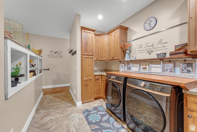 clothes washing area with cabinets and independent washer and dryer