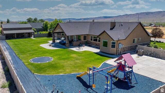 view of swimming pool featuring a trampoline, a playground, a mountain view, central AC unit, and a patio