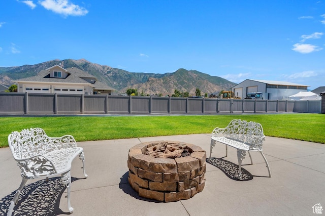 view of patio / terrace with a fire pit and a mountain view