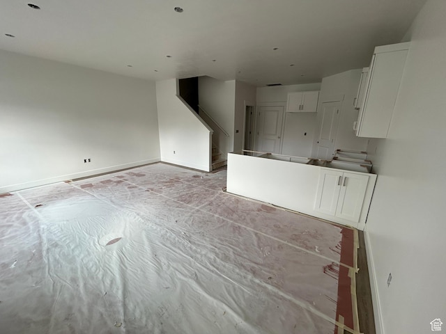 206 W 3175 S Unit T610, Nibley, UT 84321 - unfurnished living room featuring stairway and baseboards