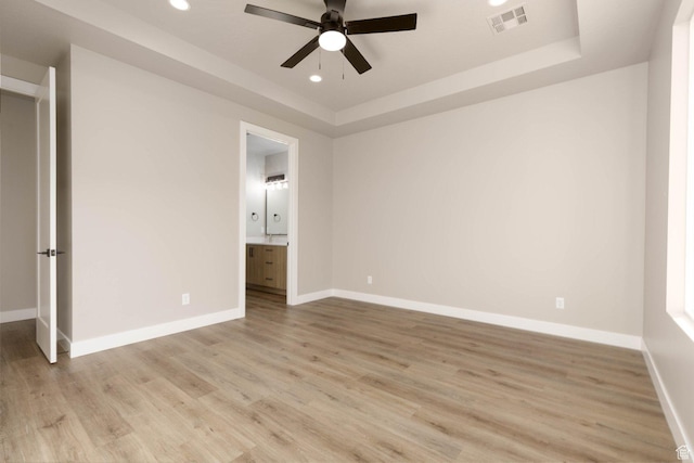 2227 W 320 S, Hurricane, UT 84737 - unfurnished bedroom with a raised ceiling, ensuite bathroom, ceiling fan, and light wood-type flooring