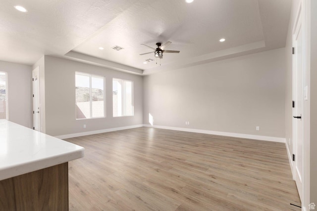2227 W 320 S, Hurricane, UT 84737 - unfurnished living room featuring a textured ceiling, light wood-type flooring, a raised ceiling, and ceiling fan