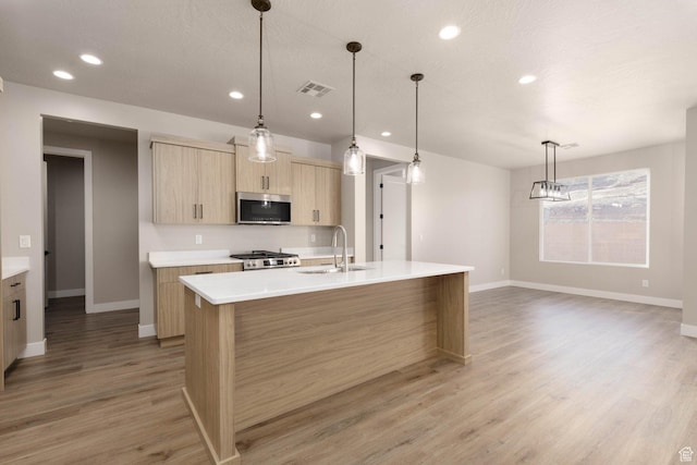 2227 W 320 S, Hurricane, UT 84737 - kitchen with pendant lighting, light brown cabinets, sink, an island with sink, and range