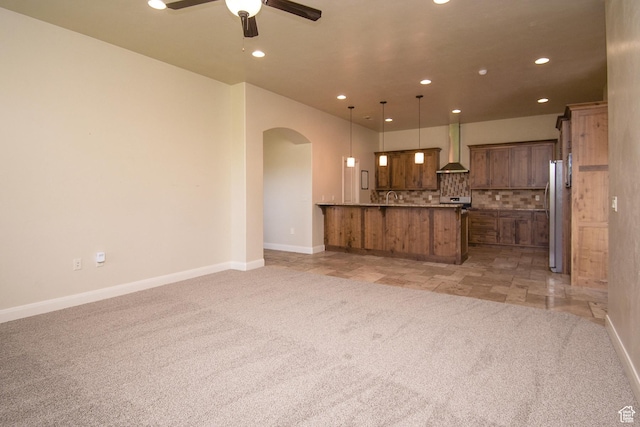 2596 S Little Valley Rd, St George, UT 84790 - kitchen featuring pendant lighting, wall chimney range hood, decorative backsplash, ceiling fan, and light colored carpet