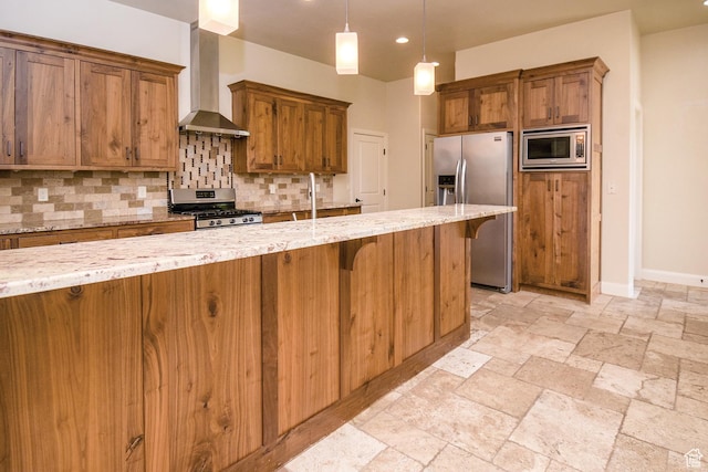 2596 S Little Valley Rd, St George, UT 84790 - kitchen featuring light stone countertops, appliances with stainless steel finishes, tasteful backsplash, wall chimney range hood, and decorative light fixtures