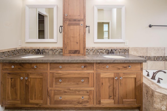 2596 S Little Valley Rd, St George, UT 84790 - bathroom featuring vanity, a relaxing tiled tub, and tasteful backsplash