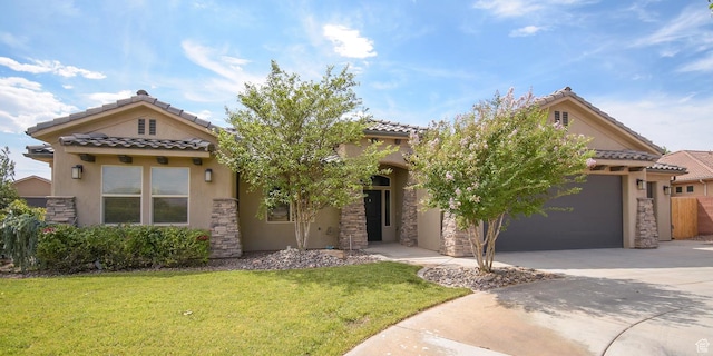 mediterranean / spanish home with a front yard and a garage