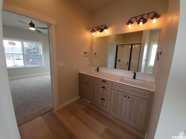 bathroom featuring ceiling fan, hardwood / wood-style floors, vanity, and a shower with shower door