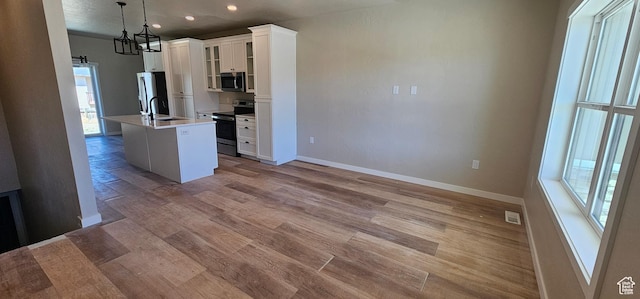 831 N 1820 E Unit 66, Price, UT 84501 - kitchen with appliances with stainless steel finishes, light wood-type flooring, decorative light fixtures, white cabinets, and an island with sink