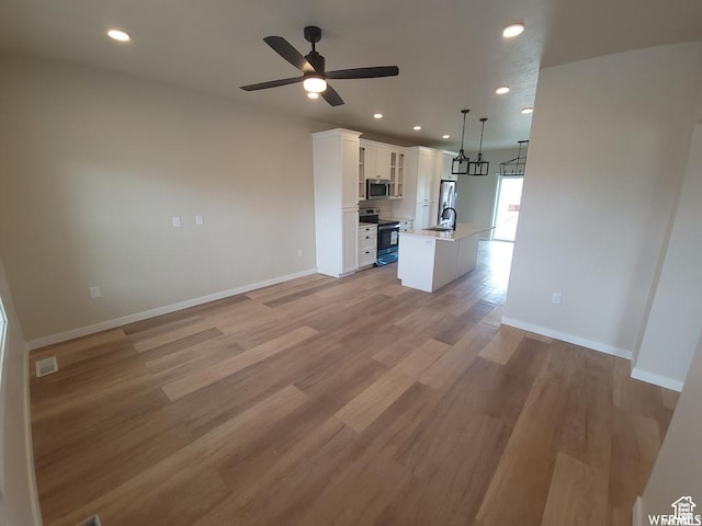 1871 E 840 N Unit 84, Price, UT 84501 - unfurnished living room with ceiling fan, sink, and light hardwood / wood-style flooring