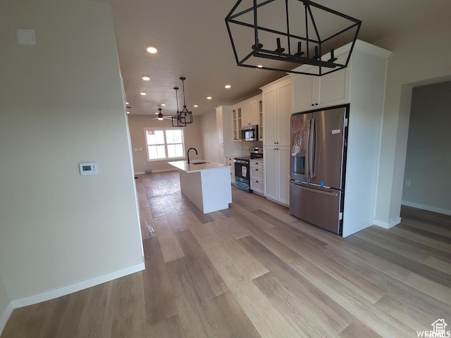 1871 E 840 N Unit 84, Price, UT 84501 - kitchen with appliances with stainless steel finishes, sink, a center island with sink, white cabinets, and hanging light fixtures