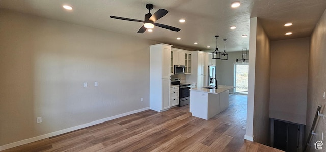 854 N 1880 E Unit 72, Price, UT 84501 - kitchen with pendant lighting, white cabinets, ceiling fan, an island with sink, and stainless steel appliances