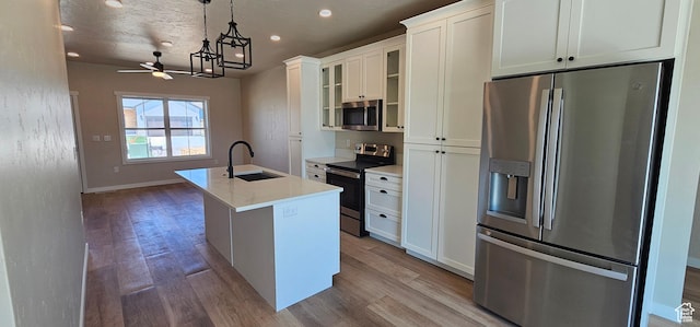 1840 E 840 N Unit 81, Price, UT 84501 - kitchen with stainless steel appliances, sink, decorative light fixtures, a center island with sink, and white cabinetry