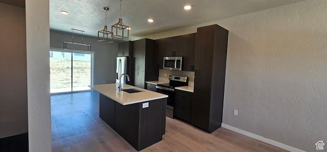 1843 E 840 N Unit 86, Price, UT 84501 - kitchen featuring a center island with sink, hanging light fixtures, sink, light hardwood / wood-style flooring, and appliances with stainless steel finishes