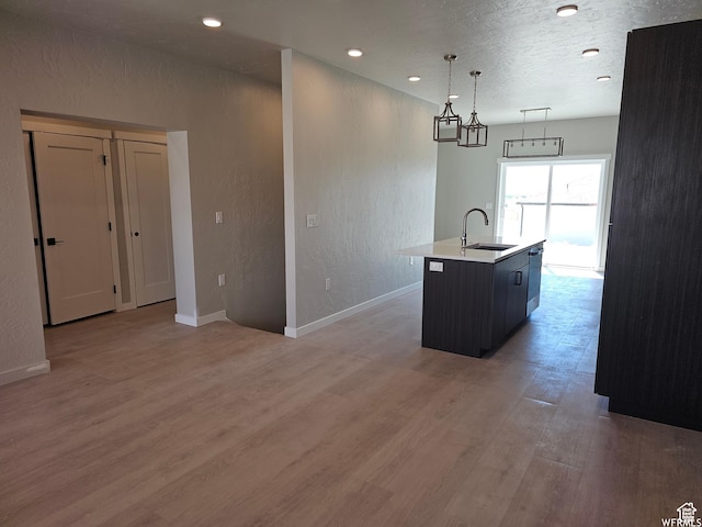 1858 E 840 N Unit 82, Price, UT 84501 - kitchen with pendant lighting, a center island with sink, sink, hardwood / wood-style flooring, and a textured ceiling