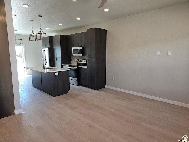 1858 E 840 N Unit 82, Price, UT 84501 - kitchen featuring hanging light fixtures, an island with sink, stainless steel appliances, and light wood-type flooring