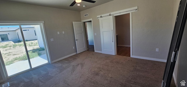 1829 E 840 N Unit 87, Price, UT 84501 - unfurnished bedroom with access to outside, a barn door, ceiling fan, and dark carpet