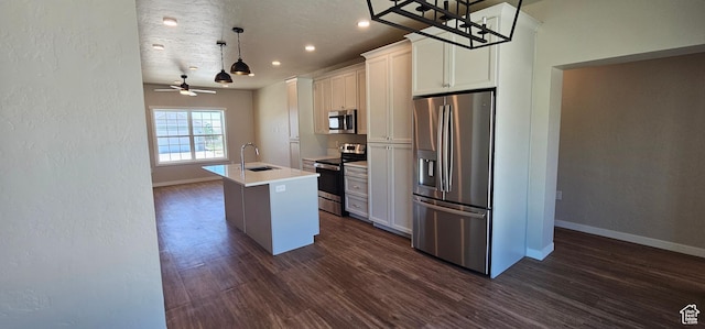 1829 E 840 N Unit 87, Price, UT 84501 - kitchen featuring a kitchen island with sink, white cabinets, ceiling fan, appliances with stainless steel finishes, and decorative light fixtures