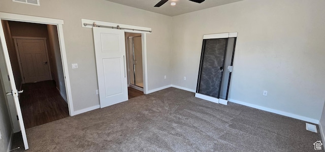 unfurnished bedroom with ceiling fan and dark colored carpet
