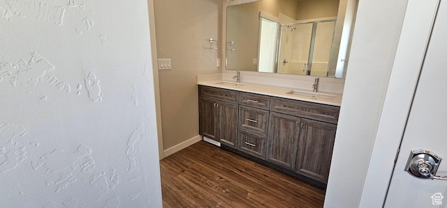 bathroom with hardwood / wood-style floors, vanity, and a shower with shower door