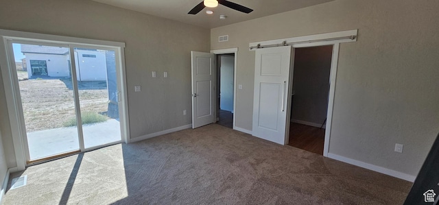 unfurnished bedroom featuring access to outside, multiple windows, ceiling fan, and carpet flooring