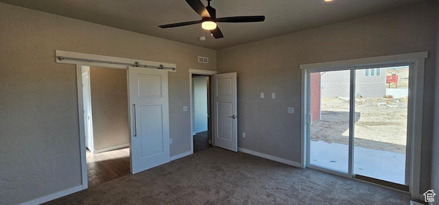 868 N 1880 E Unit 71, Price, UT 84501 - unfurnished bedroom with access to exterior, a barn door, dark carpet, and ceiling fan