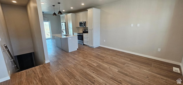 868 N 1880 E Unit 71, Price, UT 84501 - kitchen with sink, hanging light fixtures, stainless steel appliances, a center island with sink, and white cabinets