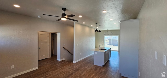 1830 E 840 N Unit 80, Price, UT 84501 - kitchen featuring ceiling fan with notable chandelier, sink, pendant lighting, dark hardwood / wood-style floors, and an island with sink