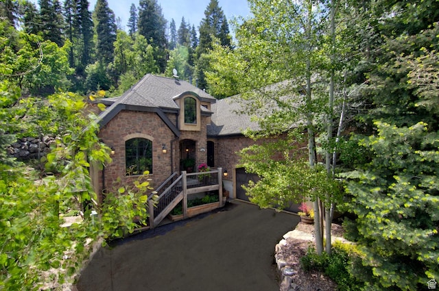 9049 N Timphaven Rd, Sundance, UT 84604 - view of front of home with a shingled roof, a garage, stone siding, and brick siding