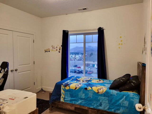 bedroom featuring visible vents, a textured ceiling, and baseboards