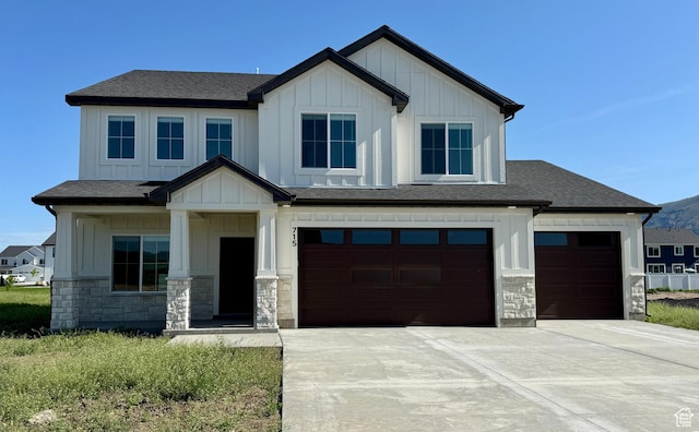 715 E 1250 S, Hyrum, UT 84319 - view of front of property with board and batten siding, stone siding, concrete driveway, an attached garage, and roof with shingles