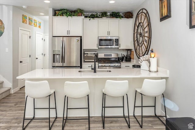 15091 S Reins Way W, Bluffdale, UT 84065 - kitchen with stainless steel appliances, a breakfast bar area, recessed lighting, and white cabinetry