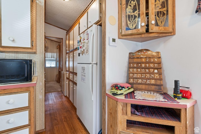 1150 W Red Hills Pkwy, Washington, UT 84780 - kitchen featuring a textured ceiling, dark wood-type flooring, crown molding, white refrigerator, and lofted ceiling