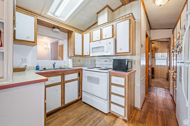 1150 W Red Hills Pkwy, Washington, UT 84780 - kitchen with sink, light hardwood / wood-style flooring, vaulted ceiling, white appliances, and white cabinets